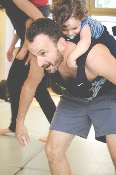 Eltern-Kind-Bewegung mit Kind auf dem Rücken